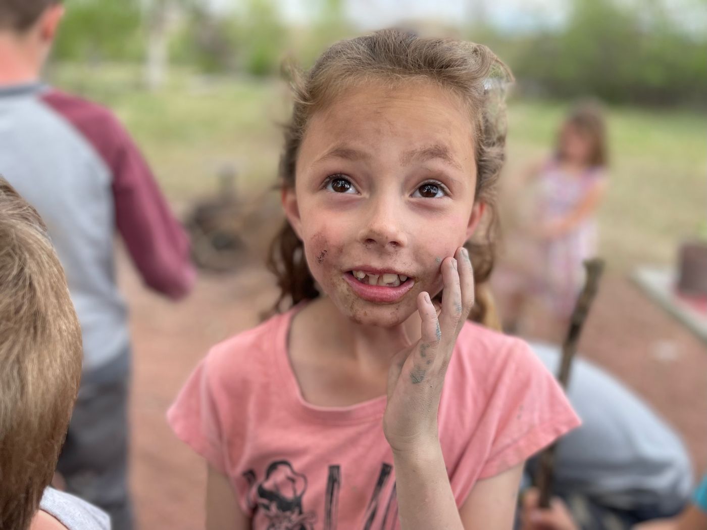 A happy child with a mud-smudged, grinning face
