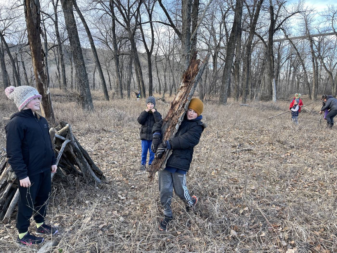 Children building a stick shelter in the coulees